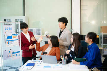 Young professionals brainstorming with laptops and reports in a modern office. Perfect for teamwork, startup, finance, strategy