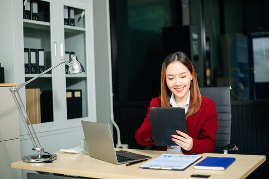 Confident businesswomen working on finance analysis with a tablet and laptop at office desk. Perfect for business, accounting