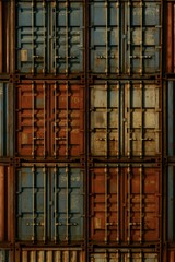 Stacked cargo containers in rusty blue and orange hues