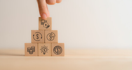 Budget and financial planning strategy concept. Wooden blocks with the icons related to budgeting, investment and financial strategy. Strategies for efficient budget allocation, budget management.