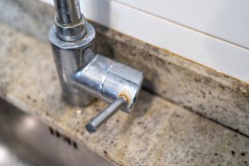 Obraz premium Dirty kitchen sink faucet contaminated with calcium and dirt.