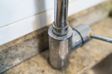 Obraz premium Dirty kitchen sink faucet contaminated with calcium and dirt.