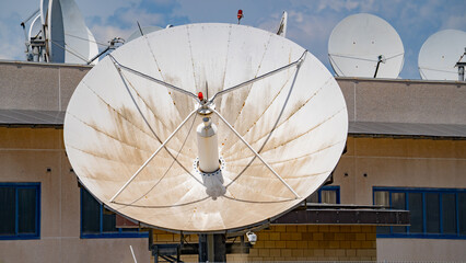 Close-up view of multiple large satellite dishes at a ground telecommunication station