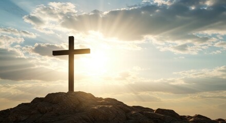 A Silhouette of a Christian Cross on a Rocky Hilltop Against a Dramatic Sky with Sunrays and Clouds