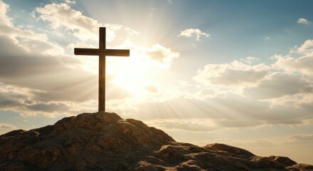 A Silhouette of a Christian Cross on a Rocky Hilltop Against a Dramatic Sky with Sunrays and Clouds