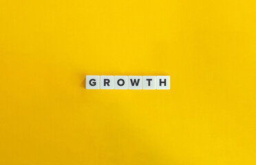 Close-up of Letter Tiles Spelling ‘Growth’ on Yellow Background.