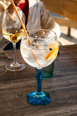 Close-up of a gin and tonic on a terrace facing the ocean