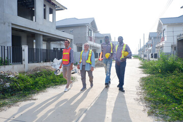 A male engineer wearing a safety helmet is walking to inspect the construction site — an engineer...