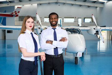 Smiling pilot students posing in aircraft hangar © alvaro