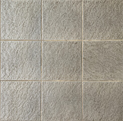 Close up of grey textured porcelain tiles suitable for floor and walls. Seamless background texture.