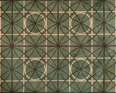 Close up of geometrical floral and circle pattern carpet rug. Green, white, and brown color. Geometrical modern floral star shapes seamless background texture.