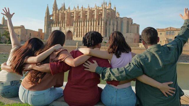Young friends relaxing together at viewpoint in Palma - Young friends sitting and enjoying the cathedral view in Palma during vacation. Concept of summer, travel, friendship
