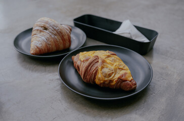 Delicious cheese croissants pastry for breakfast served on black plates.