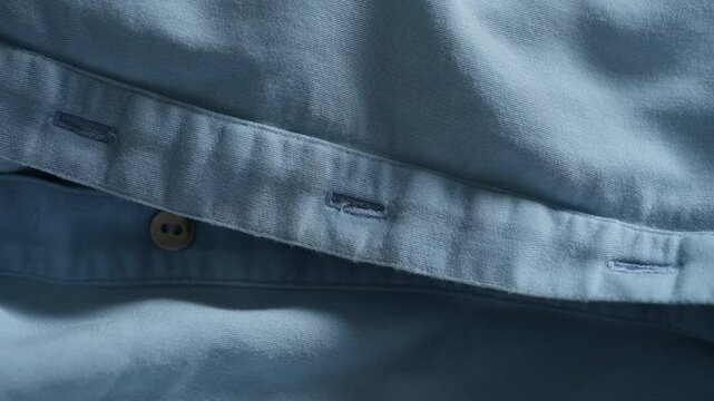 Close-up of the unbuttoned placket of a light blue dress
