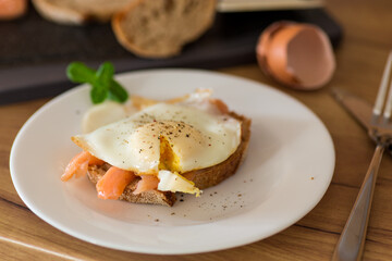 A slice of bread with lightly salted red fish and a cooked egg for breakfast