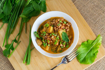 Homemade hearty dish of vegetables, meat and potatoes on a wooden background