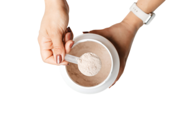Woman's hands holding measuring spoon with whey protein powder over a jar, preparing a protein drink cocktail, top view, isolated on a transparent background