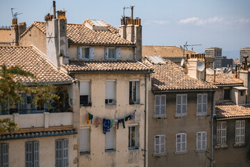 Old traditional French house facade and tiled roof with authentic laundry on the rope in Marseille, France