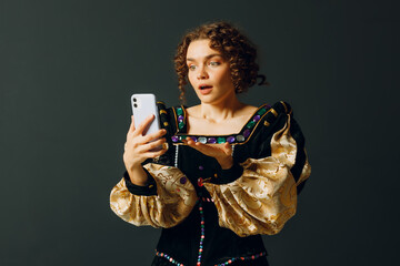 Portrait of a young aristocratic woman doing photo selfie with mobile phone and dressed in a medieval dress