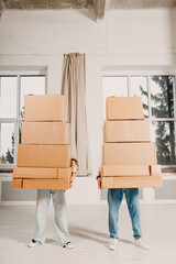Happy young family couple man and woman moving with cardboard boxes to new estate home apartment.