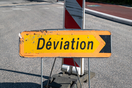 Sinal de desvio com a descri&ccedil;&atilde;o em franc&ecirc;s 'D&eacute;viation' com as tradicionais cores de amarelo e preto em meio a um  ambiente urbano