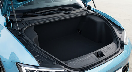 Fototapeta premium Open front trunk frunk storage of modern light blue electric car ev vehicle close up view