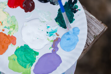 Sustainable and ecofriendly craft painting art materials are arranged on palette with brush dipping...