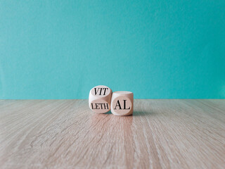 Turned a wooden cube and changes the word 'lethal' to 'vital'. Beautiful wooden table, blue...