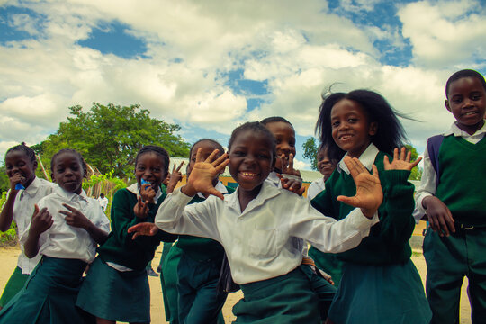 Real photo of happy black African kids in school uniforms, smiling and enjoying a break. A positive image of youth, education, diversity, and community spirit.
