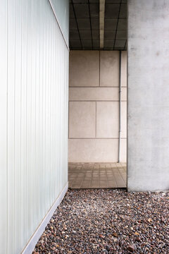 Architectural detail of minimalist white concrete wall with gravel base, clean lines and negative space, ideal for design, architecture and background visuals.