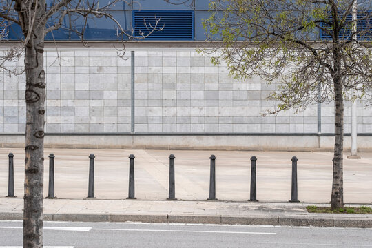 Linear design of sidewalk and bollards against concrete wall, London cityscape, showcasing geometry, urban planning, and modern city environment for design use.