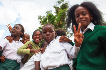 Real photo of happy black African kids in school uniforms, smiling and enjoying a break. A positive image of youth, education, diversity, and community spirit.