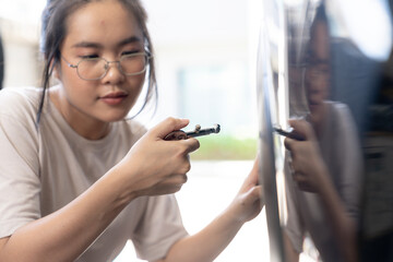 Confident young woman checking her car's tires before driving, independent lifestyle and road safety