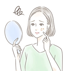 手鏡を見ながらシミについて悩む女性