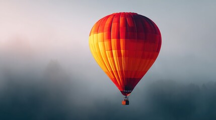 Fototapeta premium Colorful hot air balloon floats above a misty landscape.
