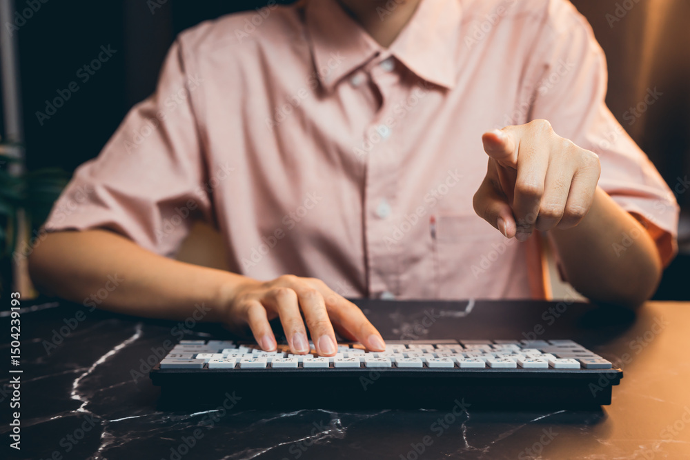 Poster person pointing at computer keyboard while working on technology in modern lifestyle setting