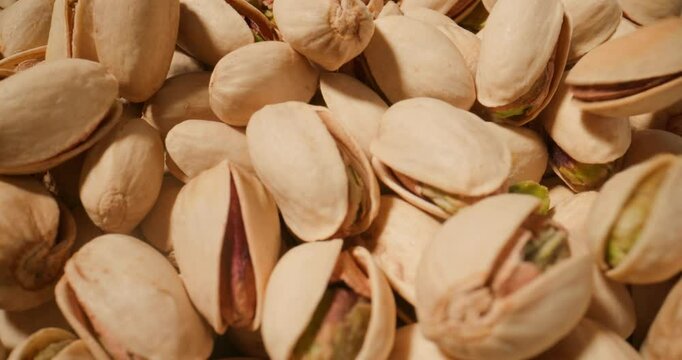 close-up capture of pistachios, with their naturally split shells and bright, flavourful cores