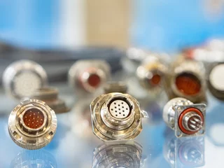 Zelfklevend Fotobehang Close-up of various industrial metal electrical connectors with multiple pins, used for high-performance cabling in automation and machinery. Electronics. Industry. Manufacturing. © Grispb