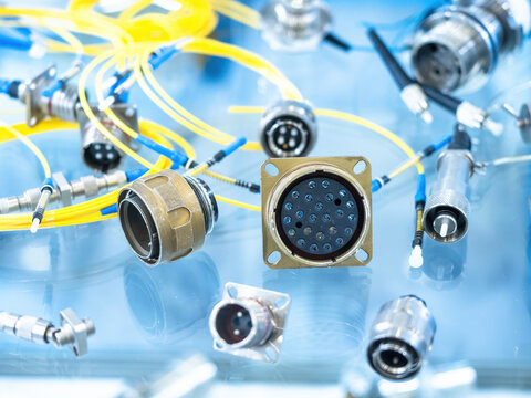 High-density circular electrical connectors with yellow fiber optic cables for data and signal transmission in industrial automation. Electronics. Industry. Communication.
