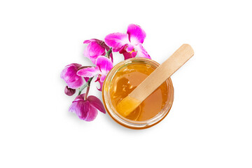 Liquid sugar paste for hair removal in bowl with orchid flower on white background. The concept of body care, beauty treatments.