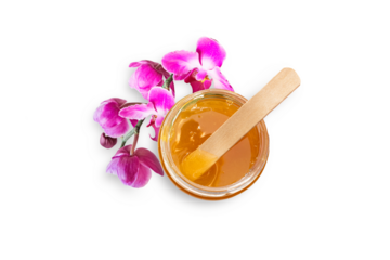 Liquid sugar paste for hair removal in bowl with orchid flower on white background. The concept of body care, beauty treatments.