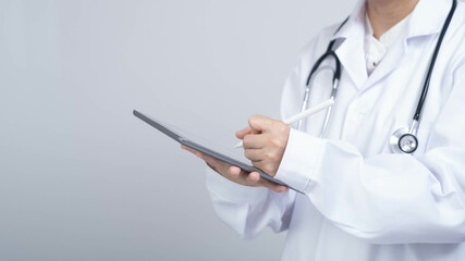 A healthcare professional in a white coat is using a tablet, symbolizing modern medicine and digital health technology.