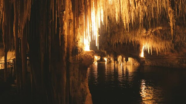 Dark deep underground cave with a lake approached by a boat.