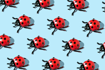 Ladybugs, a creative spring pattern on a pastel blue background.