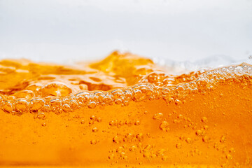 Close up bright orange Oil or beer splash texture and nature waves, Beautiful waves curve and little bubbles smooth for graphic design and background, Oil Bubbles, Soft beer bubbles, Selective focus
