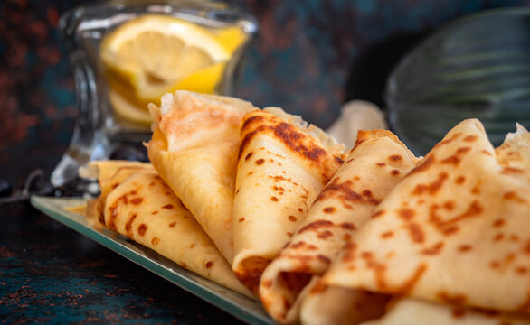 Pila de crepes caseras frescas con lim&oacute;n sobre fondo r&uacute;stico