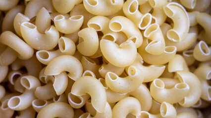 Extreme closeup of raw macaronni pasta. The sharp details enhance its appeal for editorial and marketing use.  