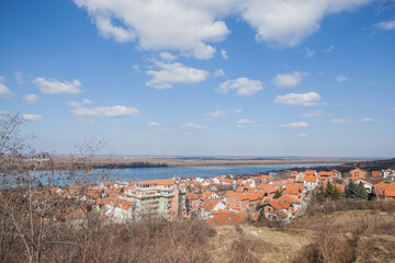  A wide-angle panoramic shot showcasing the majestic Danube River flowing alongside the charming houses with orange roofs on its banks in Belgrade, Serbia.