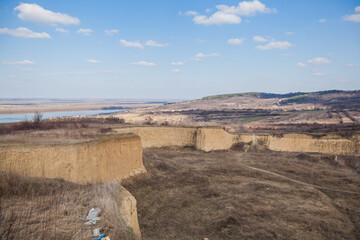 A scenic view of unique eroded loess cliffs under a bright blue sky, highlighting the natural geological formations.