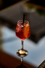 Aperol spritz cocktail with lemon and ice in a glass